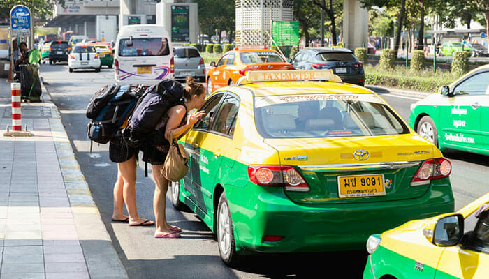 バンコクのタクシー運転手と話すバックパッカー