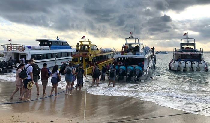 Fähren auf Bali waren Passagiere, die durch die Wellen waten mussten, um in das Boot ein- und auszusteigen
