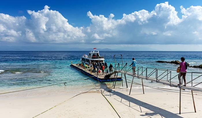 Passagiere, die eine Fähre am Strand von Nusa Penida besteigen.