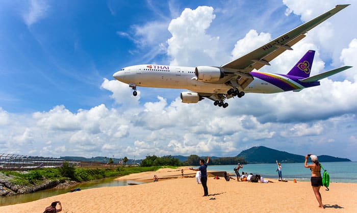 Plane flying over beach before landing at Phuket Airport