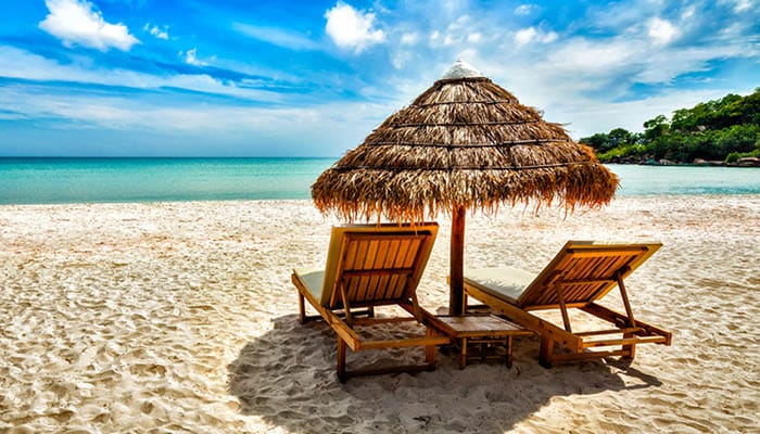 Two beach lounge chairs under tent on beach. Sihanoukville, Cambodia