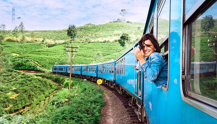 Smiling woman looks out from the train window in Sri Lanka