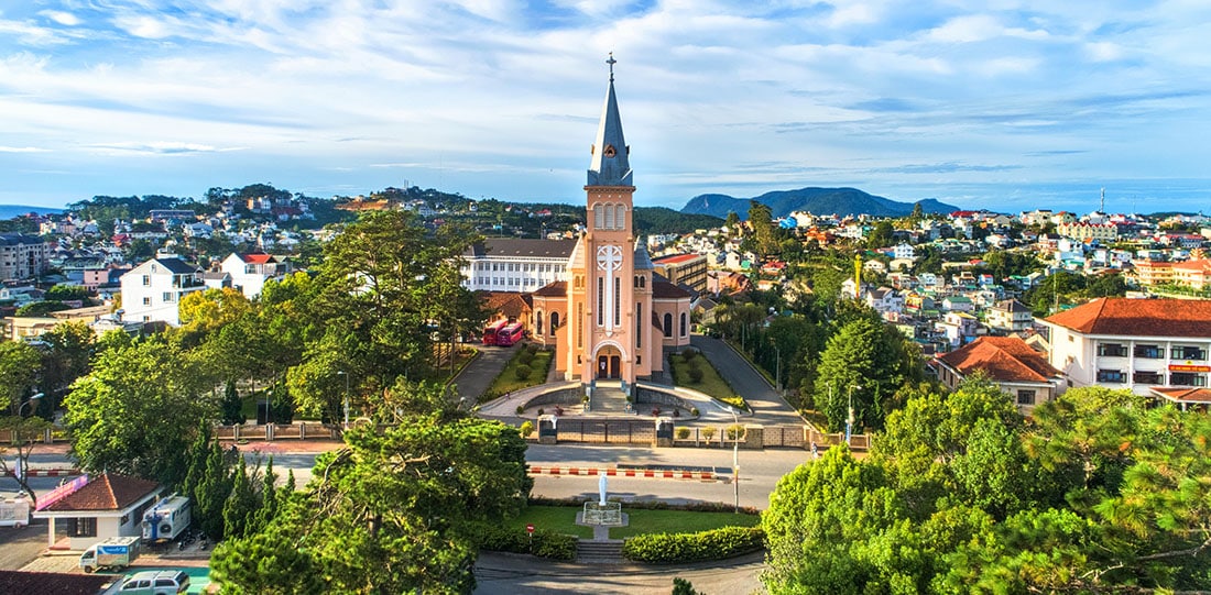 Aerial view of Chicken church in Da Lat city, Vietnam. Cloudy sky and city view and mountains behind.