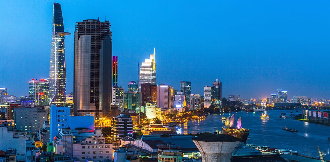 View from a rooftop of Ho Chi Minh City during sunset. With river boats and buildings.