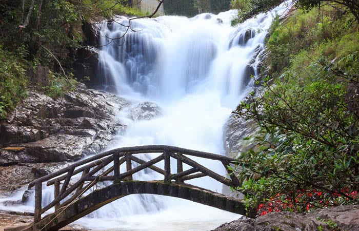 A beautiful bridge in front of peaceful Datanla Waterfalls cascades, Dalat, Vietnam, Asia. Family Outdoor Activities in most favorite tourist attractions, landmarks and landscapes near Dalat City.