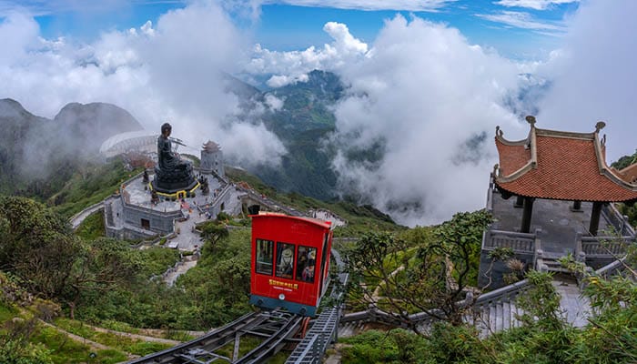 Buddha statue with tram at summit of Fansipan mountain peak the highest Indochina. Sapa Hoang Lien Son mountain range