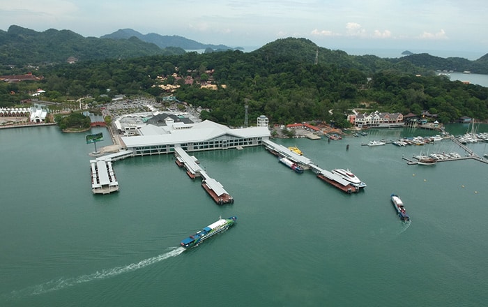 Aerial view of Kuah Jetty on Langkawi Island with various boats docked and departing.
