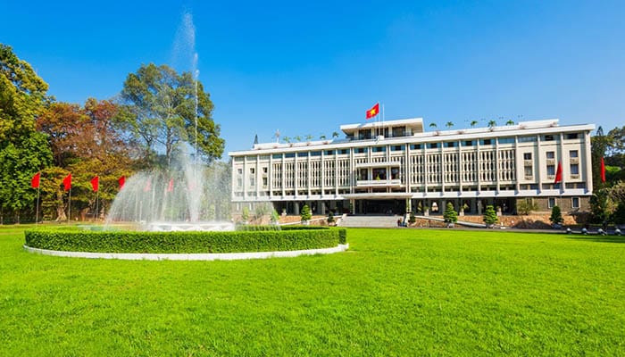 Reunification Palace with a fountain in front on a beautiful day with blue sky