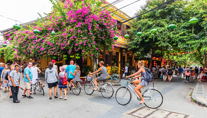 Tourists ride bicycle in the the ancient old town Hoi An