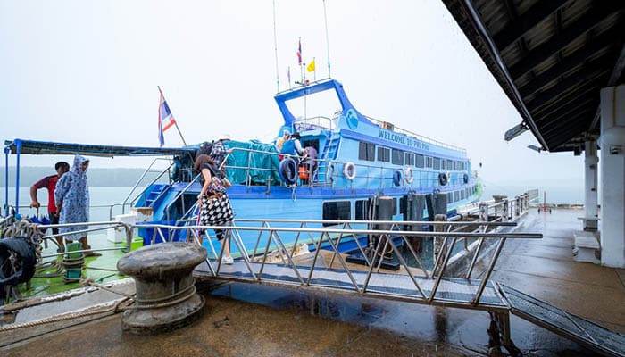 Krabi, Thailand, November 11, 2020 : Passengers in the rain to get on the ferry of the Klong Jilad Pier from Krabi to Phi Phi Island.