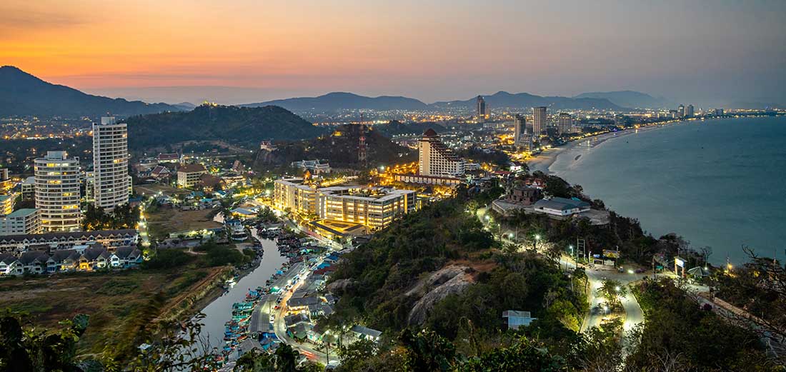 Twilight view of Hua Hin beach from Khao Takiab Mountain, showcasing the long, curved bay with fine white sand.