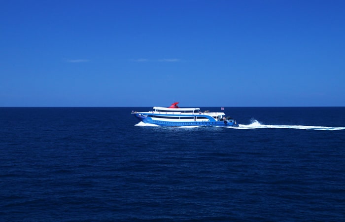 Songserm ferry cruising on the blue sea under clear skies.